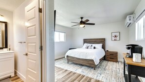 A bedroom with a bed, a ceiling fan, a nightstand, a desk, and a window. - Patio + Private Casita: Lake Havasu City Home! (Lake Havasu City)