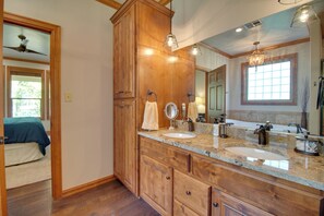 A bathroom with wooden cabinetry, two sinks, a large mirror, and a chandelier. - Pool Access, Deck & Boat Slip: Monkey Island Oasis (Afton)