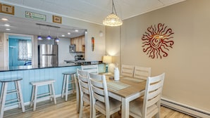 A kitchen with a refrigerator, microwave, and a dining area with a table and chairs.