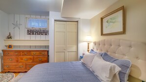 Un dormitorio con cama, cómoda y un cuadro en la pared.