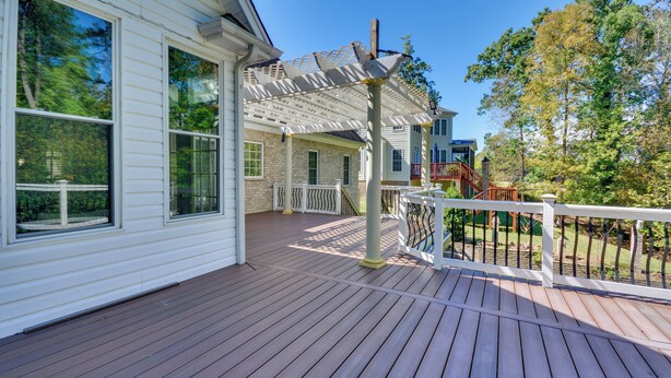 A wooden deck with a covered area and a white railing. - High Point Vacation Rental w/ Private Deck! (High Point)