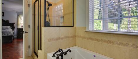 Een badkamer met een bad, een douche en een raam met zonwering.