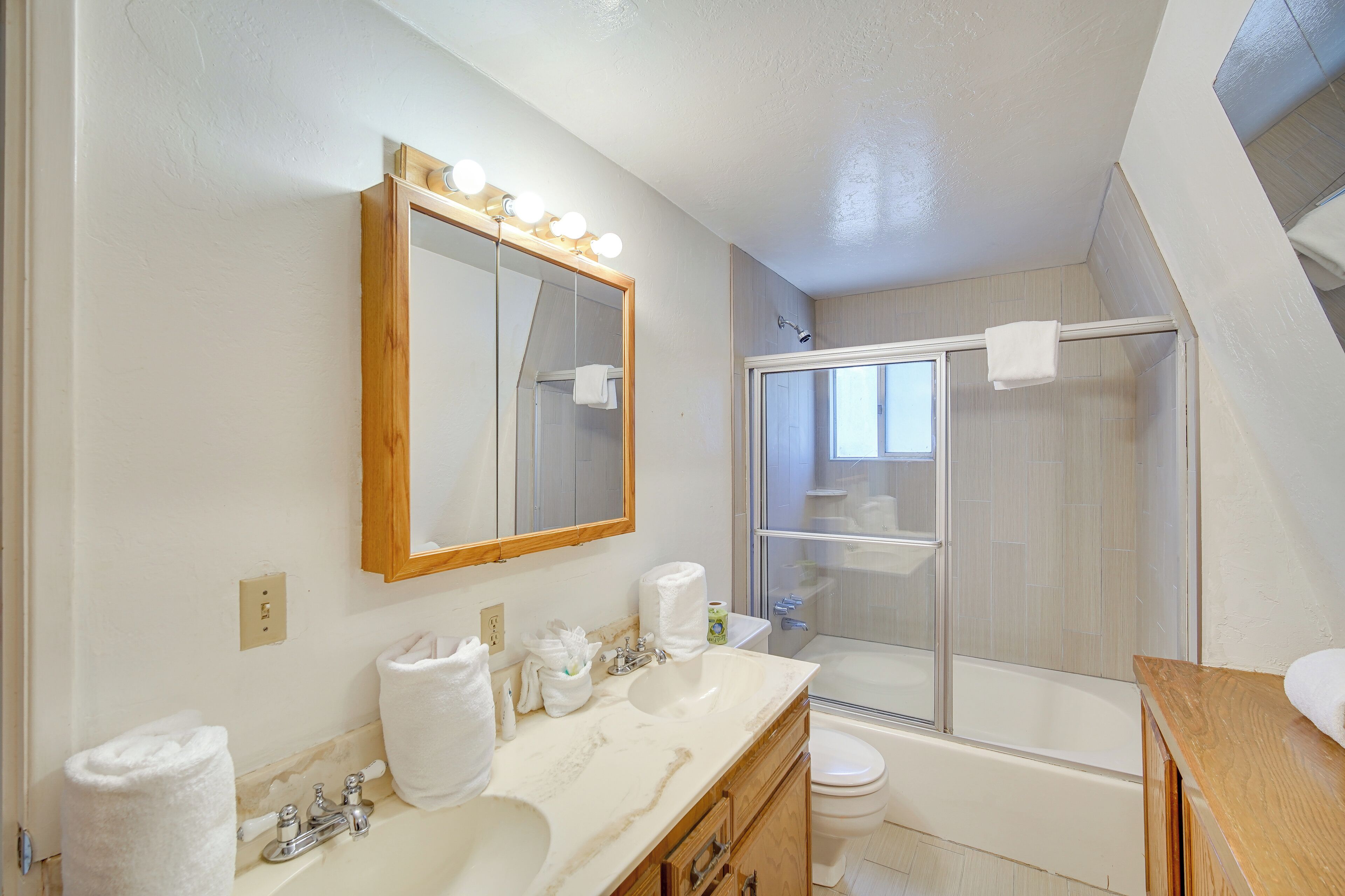 Une salle de bain moderne avec un grand miroir, un meuble-lavabo, un lavabo et une douche.