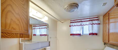 Un baño pequeño con tocador de madera, inodoro y lavadora.