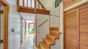 A wooden staircase leading to a second floor, with a wooden door on the right and a hallway on the left. - Ellsworth Home ~ 18 Mi to Acadia Nat'l Park! (Ellsworth)