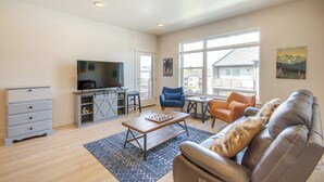 A spacious living room with a TV, a coffee table, and a sofa. - Modern Livingston Condo Near Yellowstone River! (Livingston)