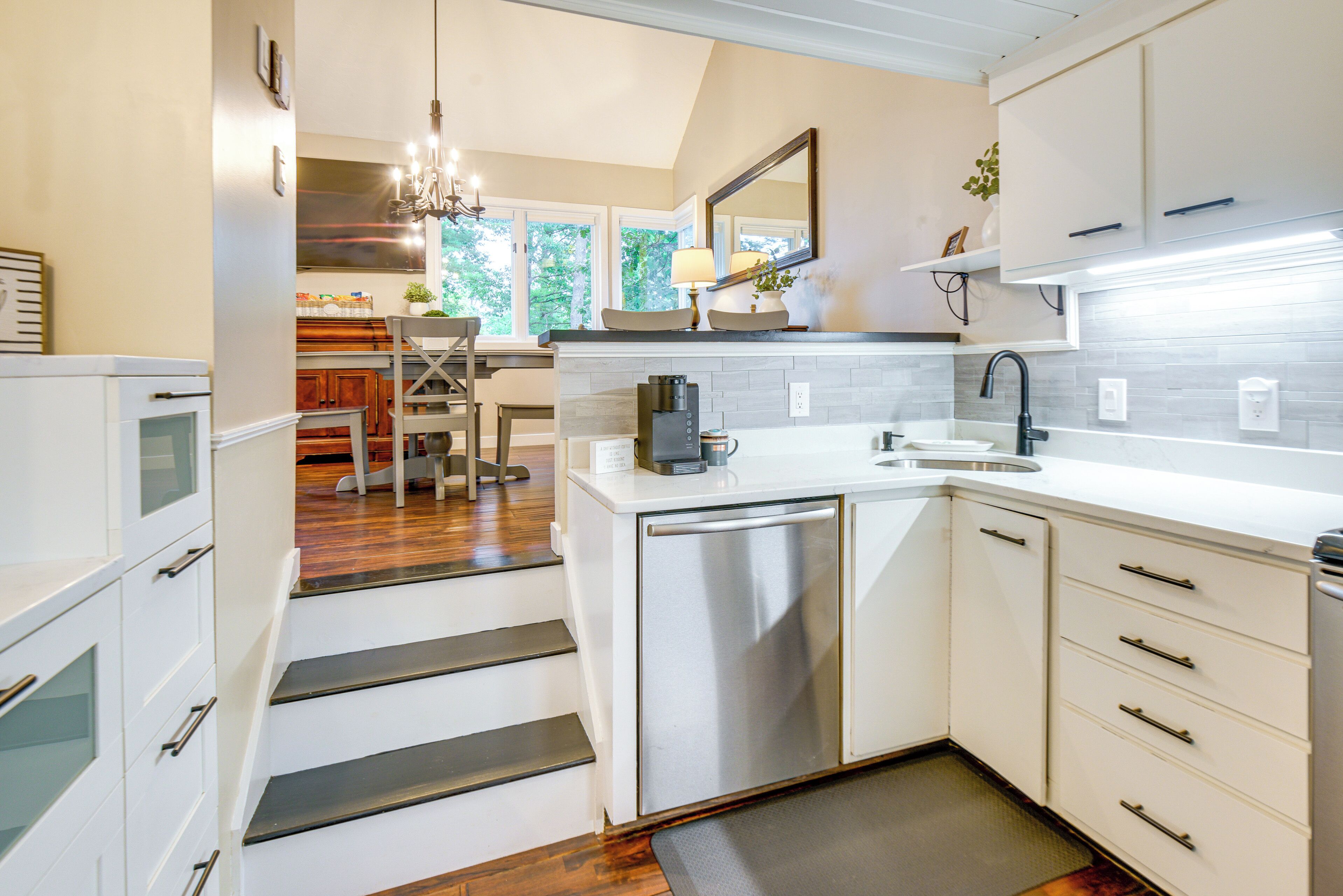 A modern kitchen with white cabinetry, stainless steel appliances, and a central island.