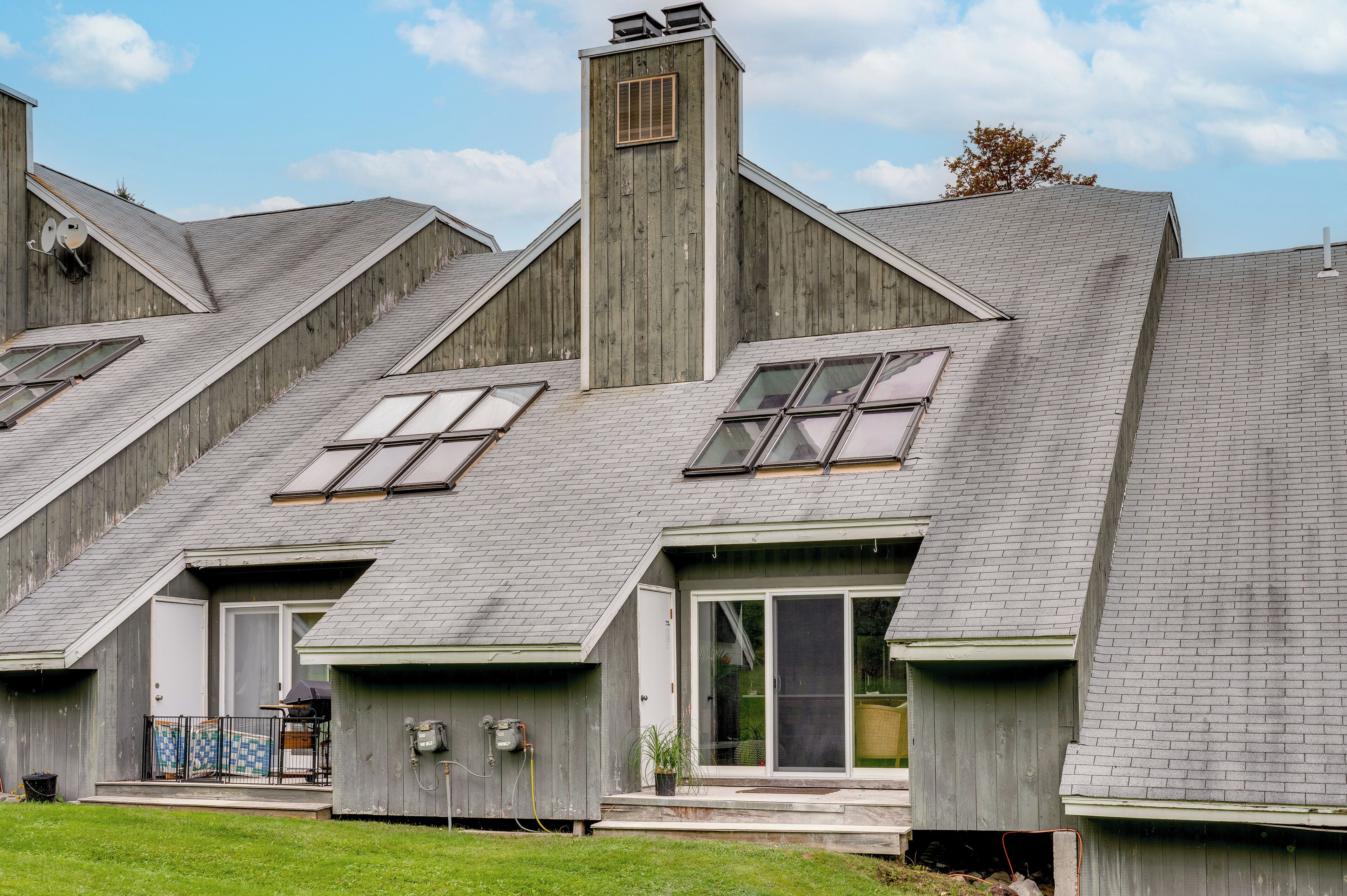 A row of wooden houses with gabled roofs and large windows.