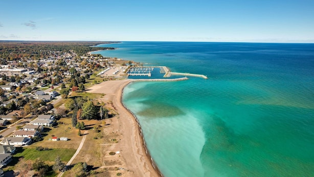 An aerial view of a coastal town with a beach, clear blue waters, and residential areas. - Dom Rodzinny Lakeview Getaway - Walk to Lake Huron (Rogers City)