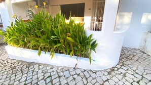 A white building with a tiled roof and a stone-paved entrance. - Albufeira Harmony With Pool by Homing (Albufeira)