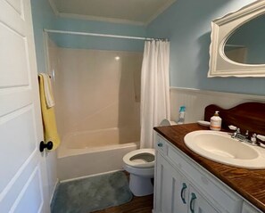 A bathroom with a bathtub, toilet, and sink.