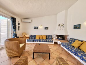 A living room with a sofa, two armchairs, a coffee table, and a fireplace. - Quinta DA Balaia Charming by Homing (Albufeira)