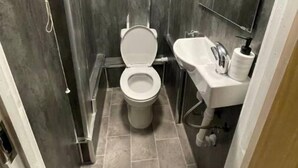 Un baño pequeño con inodoro, lavamanos y espejo.
