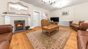 A living room with a fireplace, a television, a sofa, and a coffee table.
