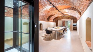 Un intérieur moderne avec une longue table à manger, des chaises et un plafond en briques.