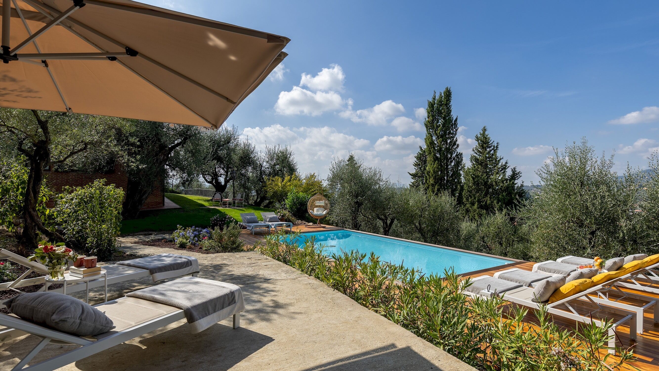 A pool area with lounge chairs and a pergola.