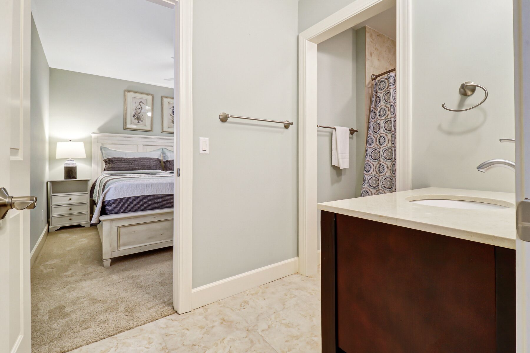 Un dormitorio con cama, mesita de noche y lámpara.