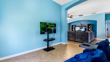 A living room with a TV, a sofa, and a coffee table.