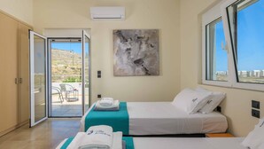 Une chambre d’hôtel avec deux lits, un balcon et une vue sur le paysage.