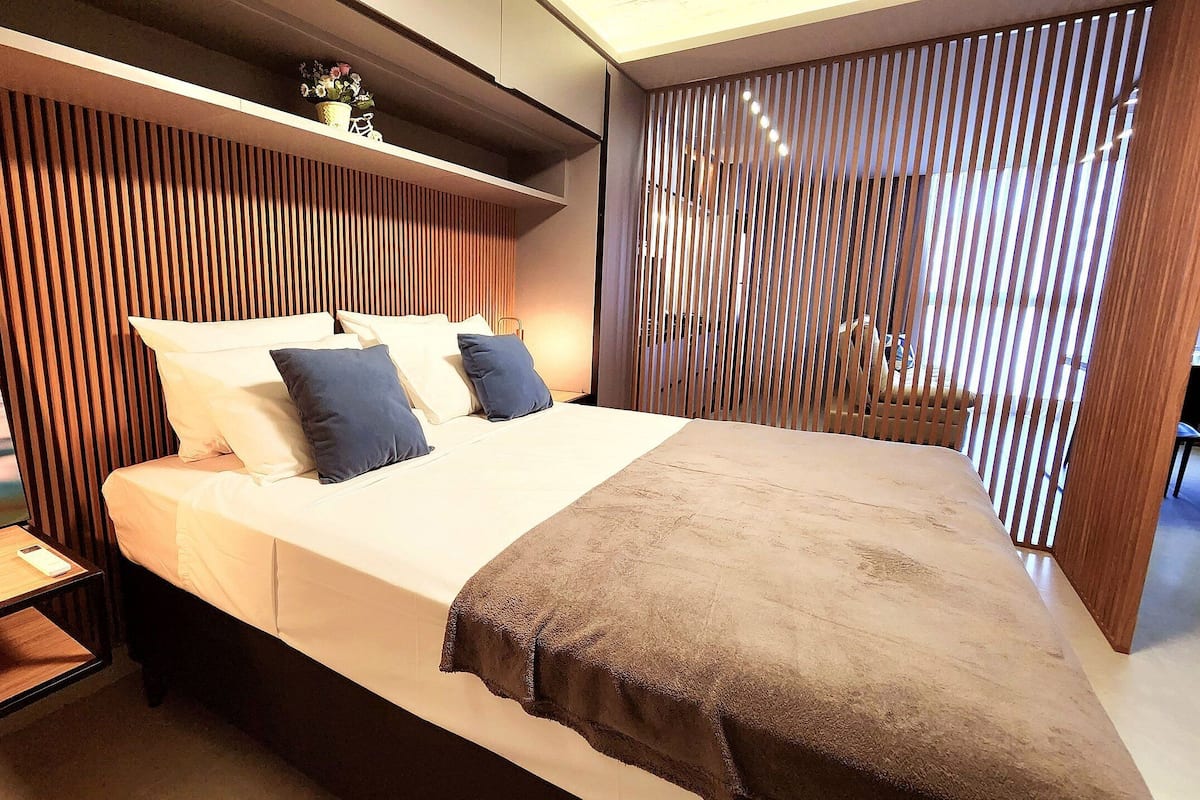 A modern bedroom with a bed, nightstands, a lamp, and a decorative item on the nightstand.