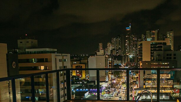 A rooftop pool with a city view at night. - Urban by Hosppedar (João Pessoa)