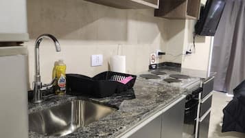 Full-sized fridge, oven, cookware/dishes/utensils, cleaning supplies