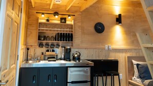 Eine kleine Küche mit Holzbalken, einem Einbauherd und einer Kaffeemaschine.