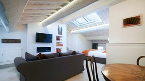 Un salon moderne avec un canapé, un téléviseur et une table à manger.