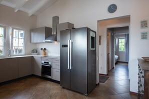A modern kitchen with stainless steel appliances, a built-in oven, and a large refrigerator.