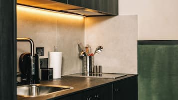 Une cuisine moderne équipée d’un évier en acier inoxydable, d’une machine à café et d’un distributeur d’essuie-tout.