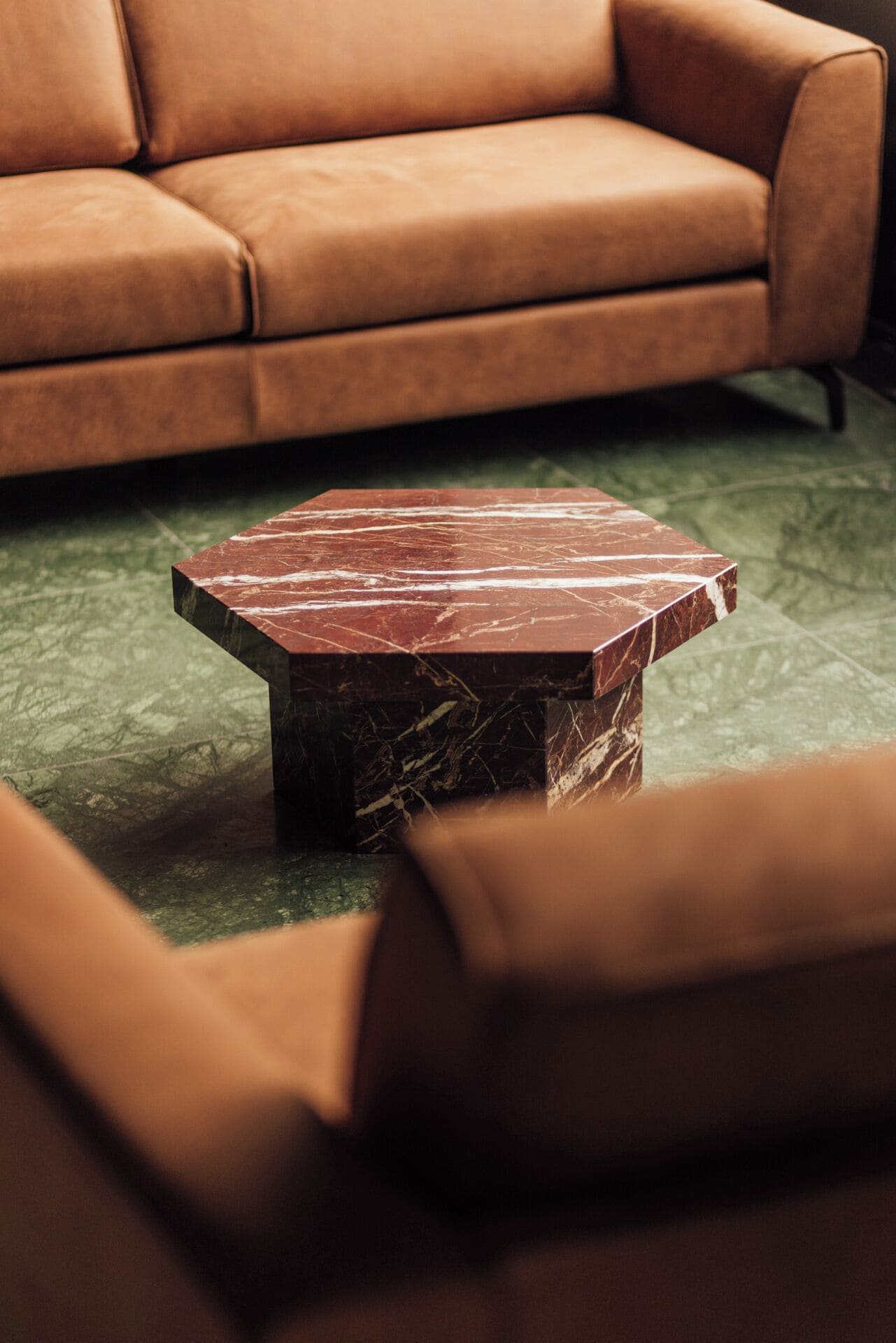 Un salon moderne avec un canapé en cuir et une table basse en marbre.
