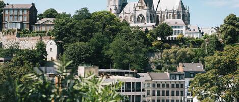 A historic church with a prominent tower and Gothic architecture, surrounded by residential buildings and lush greenery.
