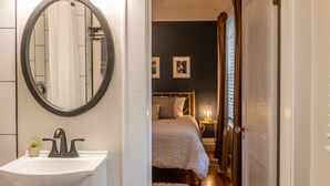 A bathroom with a white sink, a mirror, and a small potted plant. - New Listing! - Bungalow on Belmar, 4 Bed Sleeps 6. Walk to Lake Hollingsworth!  (Lakeland)