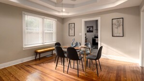 A dining area with a round glass table, black chairs, a wooden bench, and a ceiling fan. - New Listing! - Bungalow on Belmar, 4 Bed Sleeps 6. Walk to Lake Hollingsworth!  (Lakeland)