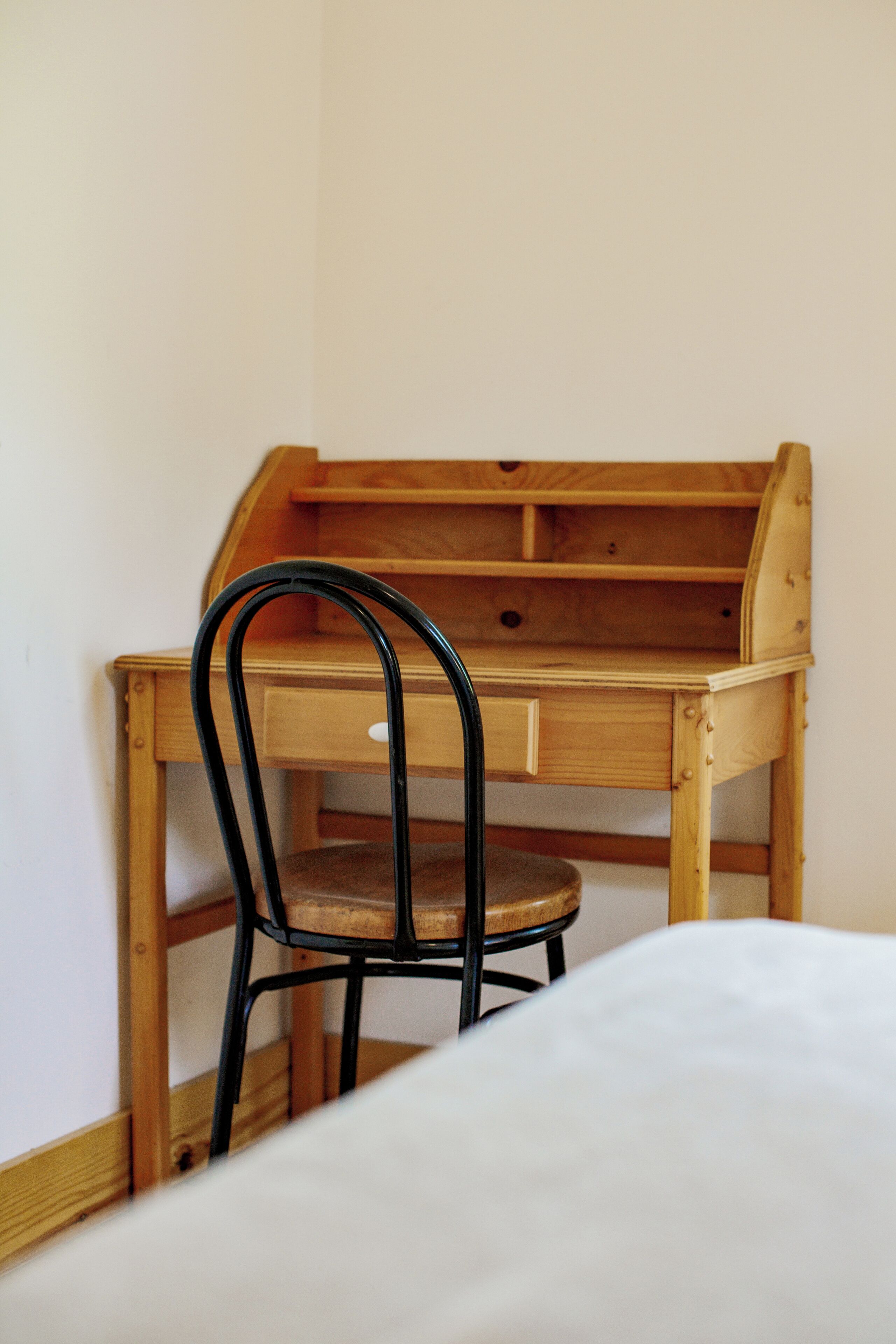 Ein Holztisch mit Stuhl, Schublade und Ablagefläche.