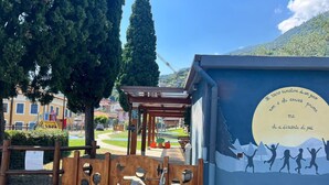 A playground with climbing structures and a mural of silhouetted figures. - Amazing Lage View Apartment With Pool and 2 Terraces (Calozzo)