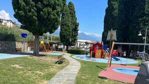 A playground with a paved path, swings, and slides. - Amazing Lage View Apartment With Pool and 2 Terraces (Calozzo)