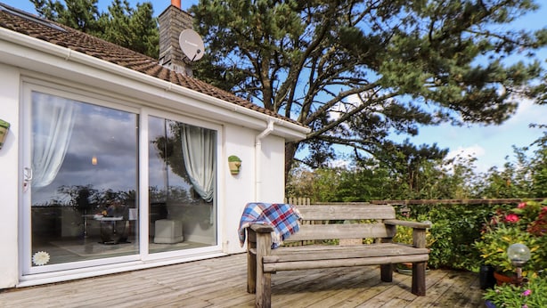 A wooden deck with a bench and a potted plant. - Little Roskrow (Penryn)