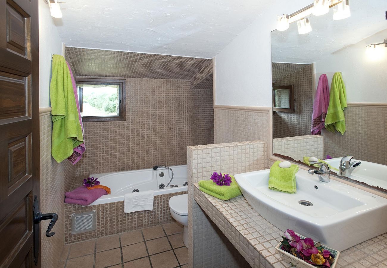 A bathroom with a bathtub, toilet, and sink. There are towels and a mirror.