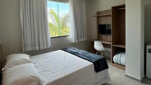 A bedroom with a bed, a desk, a chair, a TV, and a wardrobe. - Hotel Penedo Inn (Itatiaia)