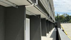 A modern building with a flat roof and a series of balconies. - Hotel Penedo Inn (Itatiaia)