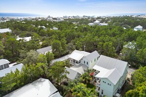 A coastal residential area with houses surrounded by dense greenery and a view of the ocean. - 30A Beach House - Beach Please (Santa Rosa Beach)