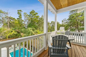 A wooden deck with a pool, surrounded by lush greenery and trees. - 30A Beach House - Beach Please (Santa Rosa Beach)