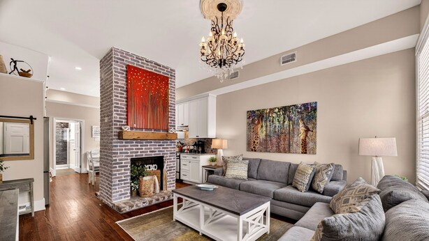Un salon avec une cheminée, un canapé, une table basse et un tableau au mur.