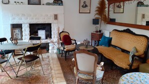 A living room with a fireplace, a sofa, a dining table with chairs, and a large mirror. - Maison Éclusière Napoléonienne, Havre de Paix au Bord du Canal D'ille et Rance (Hédé-Bazouges, Hédé)
