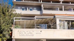 A multi-story building with balconies and a sign for "ROGAC Rooms & Restaurant". - Rogač Rooms & Restaurant (Dugi Rat)