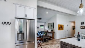 A modern kitchen with stainless steel appliances, a wooden floor, and a dining area with a table and chairs. - Stunning New Horse and Hare Inn (Murphys)