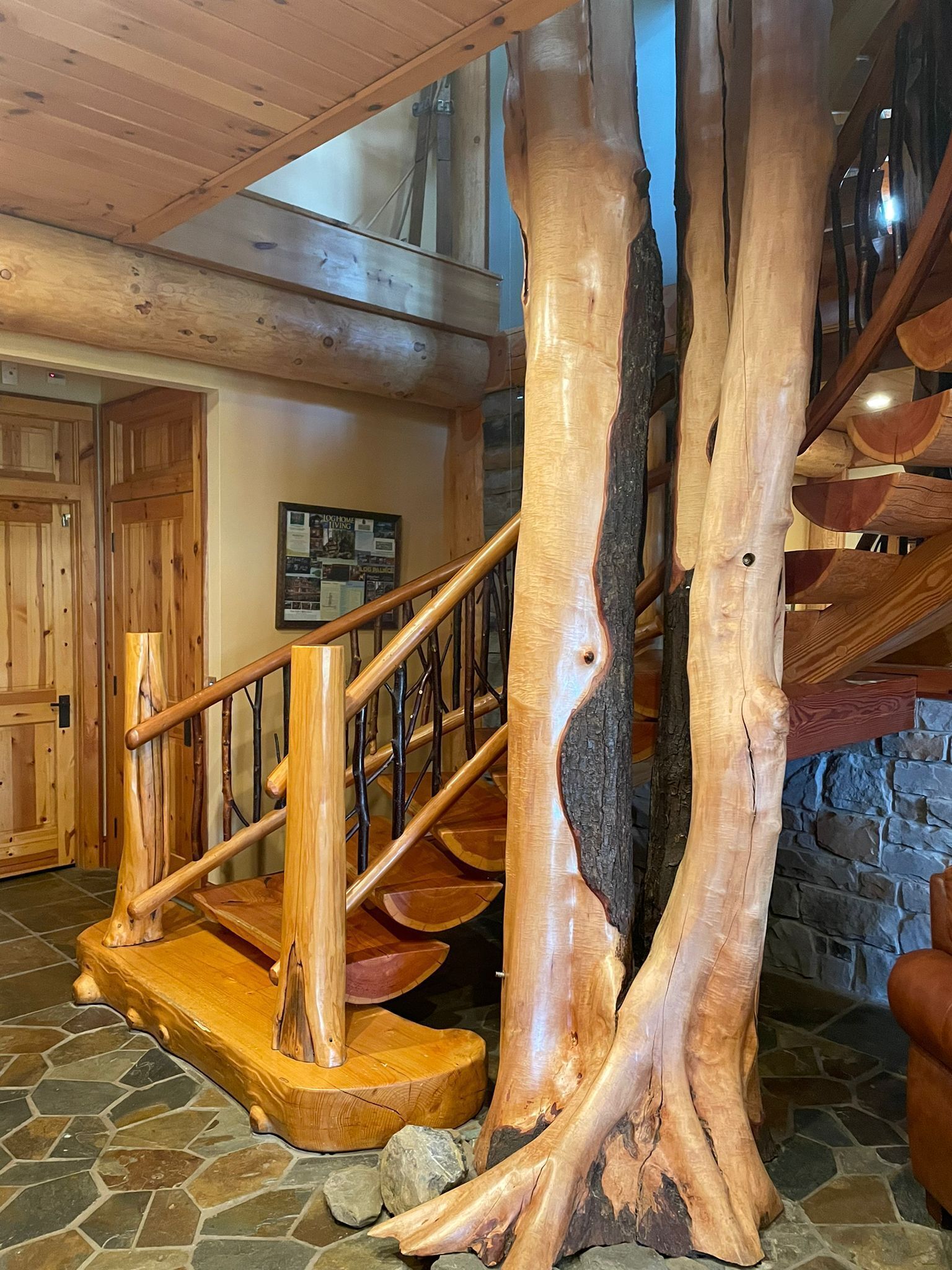 A wooden staircase with a rustic design, surrounded by stone walls and wooden paneling.