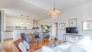 A modern living room with a sofa, chairs, a dining area, and a kitchen. - Casa Buccellato in Lucca (Lucca)