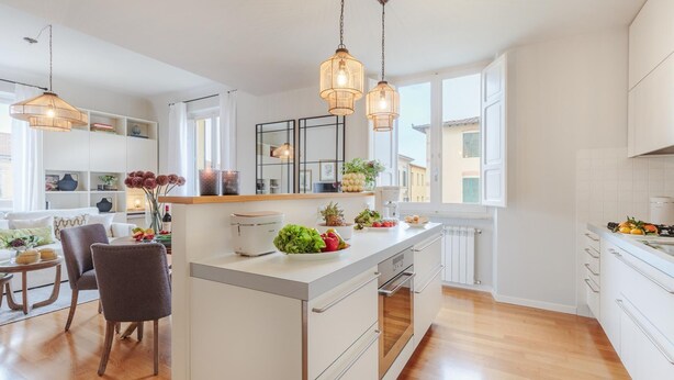A modern kitchen with white cabinetry, wooden countertops, and pendant lighting. - Casa Buccellato in Lucca (Lucca)